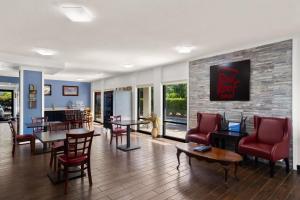 金斯蘭的住宿－紅屋頂金士蘭酒店，客厅配有红色的椅子和桌子