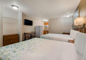 a hotel room with two beds and a television at HomeTowne Studios by Red Roof Orlando - UCF Area in Orlando