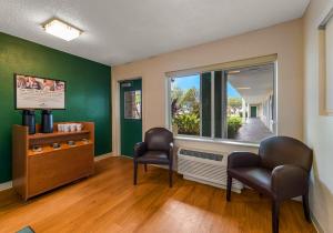 a waiting room with two chairs and a window at HomeTowne Studios by Red Roof Orlando - UCF Area in Orlando