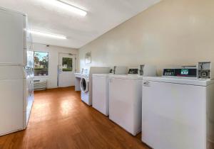 a laundry room with white washers and dryers in it at HomeTowne Studios by Red Roof Orlando - UCF Area in Orlando
