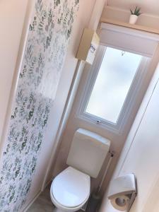 a bathroom with a toilet and a window at Bungalow Cosy équipé in La Boissière-de-Montaigu +26 photos