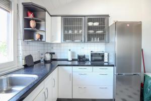a kitchen with white cabinets and a stainless steel refrigerator at nJoy! Modern & Zentral - WLAN - Badewanne - perfekt für Work & Travel in Göppingen