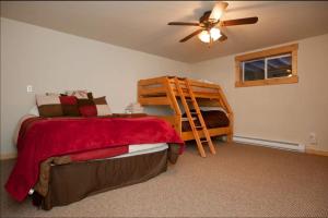 a bedroom with a bed and a bunk bed with a ladder at Cozy Townhouse on the main bus line in Breckenridge