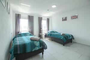 1 dormitorio con 2 camas y ventana en nJoy! Modern & Zentral - WLAN - Badewanne - perfekt für Work & Travel en Göppingen