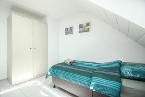 a bedroom with a bed in a white room at nJoy! Modern & Zentral - WLAN - Badewanne - perfekt für Work & Travel in Göppingen +6 photos