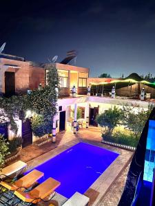 une grande maison avec une piscine en face de celle-ci dans l'établissement Riad Rime Garden Marrakech, à Marrakech