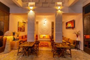 a living room with two wooden tables and a fireplace at Riad Ambre et Jasmin in Marrakech