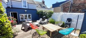 une terrasse en bois avec une table et des chaises. dans l'établissement Home Sweet Home, au Mans