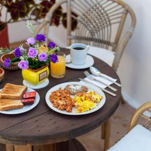 a table with a breakfast of eggs and toast at Hill House Mazatlan - Bed & Breakfast in Mazatlán
