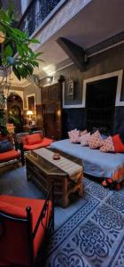 a room with two beds and a table and a couch at Riad des Mile Nuits in Marrakesh