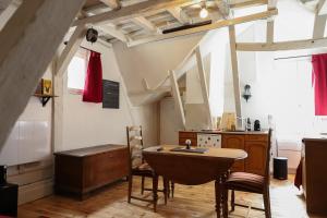 a kitchen with a table and chairs in a room at La tanière du sorcier in Saumur