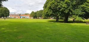 a large green field with trees and a building at Entire house in Retford city centre in Retford