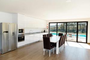 a kitchen with a table and chairs and a refrigerator at Casa dos Mirtilos Duke T8 in Celorico de Basto