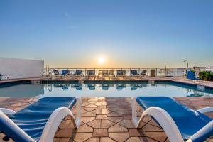 a swimming pool with lounge chairs at Tropical Winds Resort Hotel in Daytona Beach