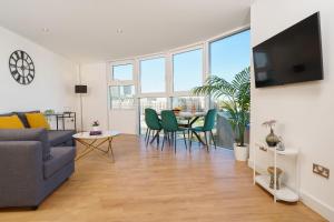 a living room with a couch and a table with chairs at Attractive London Apartment in London