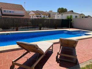 a pair of chairs sitting next to a swimming pool at Holiday house with private pool, Costa de la Luz in El Portil