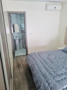 - une chambre avec un lit, un miroir et un lavabo dans l'établissement Chez Dani, à Agadir