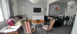 - un salon avec un canapé, une table et des chaises dans l'établissement Home Sweet Home, au Mans