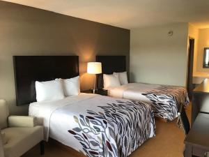 una habitación de hotel con 2 camas y una silla en Red Roof Inn Somerset, PA en Somerset