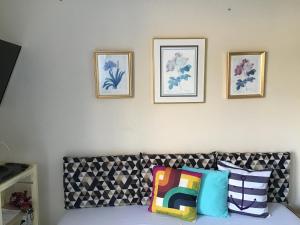 a room with a couch and three pictures on the wall at Quitieenete Arraial do Cabo in Arraial do Cabo