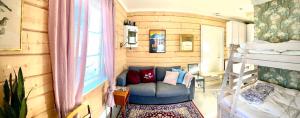 ein Zimmer mit Couch in einem winzigen Haus in der Unterkunft Scenic small guesthouse on horse farm by the lake in Frösö
