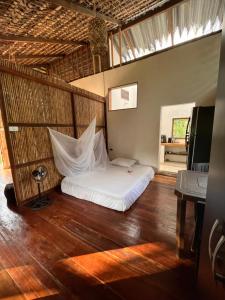 ein Schlafzimmer mit einem weißen Bett in einem Zimmer in der Unterkunft Popochos Beach Eco-Lodge in Nuquí