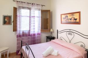 スコペッロにあるHoliday home Giardinoのベッドルーム1室(ピンクベッド1台、窓付)