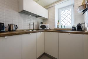 a kitchen with white cabinets and a microwave at Altre Stelle Suite Apartments in Pozzuoli