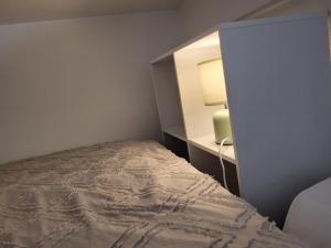 une chambre avec un lit et une armoire avec une lampe dans l'établissement Studio Mezzanine Centre-ville, à Poitiers