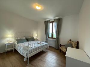 a white bedroom with a bed and a window at Agriturismo Nonno Dante - Casa Leccino in Castiglion Fibocchi