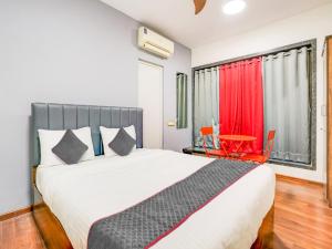 um quarto com uma cama grande e uma cortina vermelha em Sairup Stays em Navi Mumbai