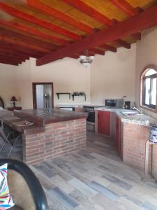 een grote keuken met houten plafonds en een bakstenen vloer bij Rancho Espinoza La Casita in San Ignacio