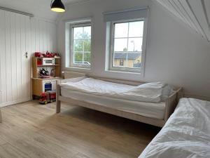 - une chambre avec 2 lits et 2 fenêtres dans l'établissement Stort familie hus (156 m2) tæt på natur og storby, à Herlev