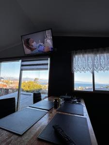 ein Büro mit einem Schreibtisch mit zwei Fenstern und einem Monitor in der Unterkunft Hostal y Cabañas Mirando al Mar in Puerto Montt