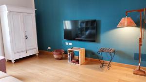 Borgo San Giuliano في ريميني: غرفة معيشة مع جدار أزرق مع تلفزيون