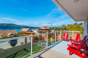 een balkon met rode stoelen en uitzicht op het water bij Outdoor Lovers in Port Alberni