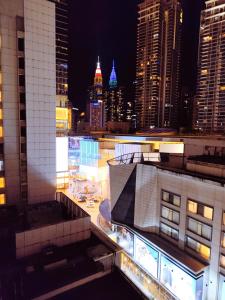 uma vista para o horizonte da cidade à noite em Fahrenheit Pavilion By Cally Stay em Kuala Lumpur