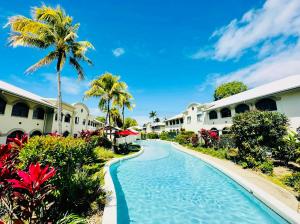 un complejo con piscina con palmeras y casas en Appartment in Palm Cove en Palm Cove