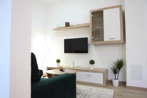 a living room with a couch and a tv on a wall at Apartman Tip Top in Gospić