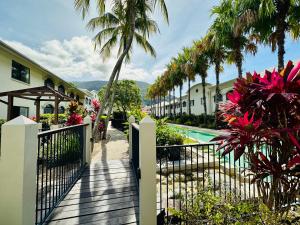 una valla junto a un complejo con piscina y palmeras en Appartment in Palm Cove en Palm Cove