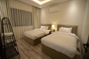 una habitación de hotel con 2 camas y una escalera en روز رزيدنس, en Riad