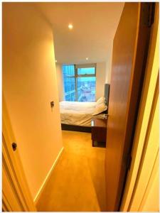 a hallway with a bedroom with a bed and a window at lovely one bedroom apartment in Ilford town in Ilford