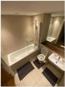 a bathroom with a tub and a toilet and a sink at lovely one bedroom apartment in Ilford town in Ilford