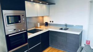 a kitchen with a sink and a stove top oven at lovely one bedroom apartment in Ilford town in Ilford