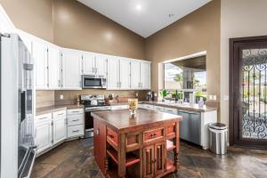 a kitchen with white cabinets and a wooden island at Desert Sojourn in Phoenix