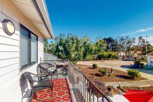 a balcony with two benches and a patio with a yard at Hazel Eyes in Nipomo
