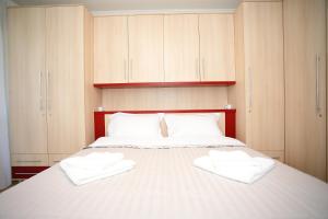 ein Schlafzimmer mit einem Bett mit weißen Handtüchern darauf in der Unterkunft Feel Like Home in Chişinău