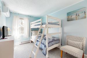 1 dormitorio con litera blanca y silla en Island Breeze, en Oak Bluffs