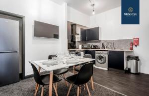 a dining room with a table and chairs and a kitchen at 2 BED LAW - 2 rooms, 4 Double Beds, Fully Equipped, Free Parking, WiFi, 3xSmart TVs, Trades, Groups, Families, Food, Shops, Bars, Short - Long Stays, Weekly or Monthly Rates Available by SUNRISE SHORT LETS in Dundee