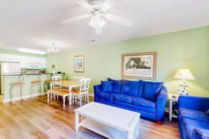 uma sala de estar com um sofá azul e uma mesa em The Singing Gull em Myrtle Beach